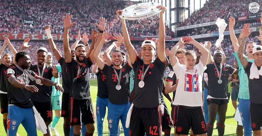 Hình ảnh cầu thủ Bayern Munich nâng cao đĩa bạc ăn mừng chức vô địch Bundesliga 2021-2022 sau chiến thắng quyết định trước Borussia Dortmund